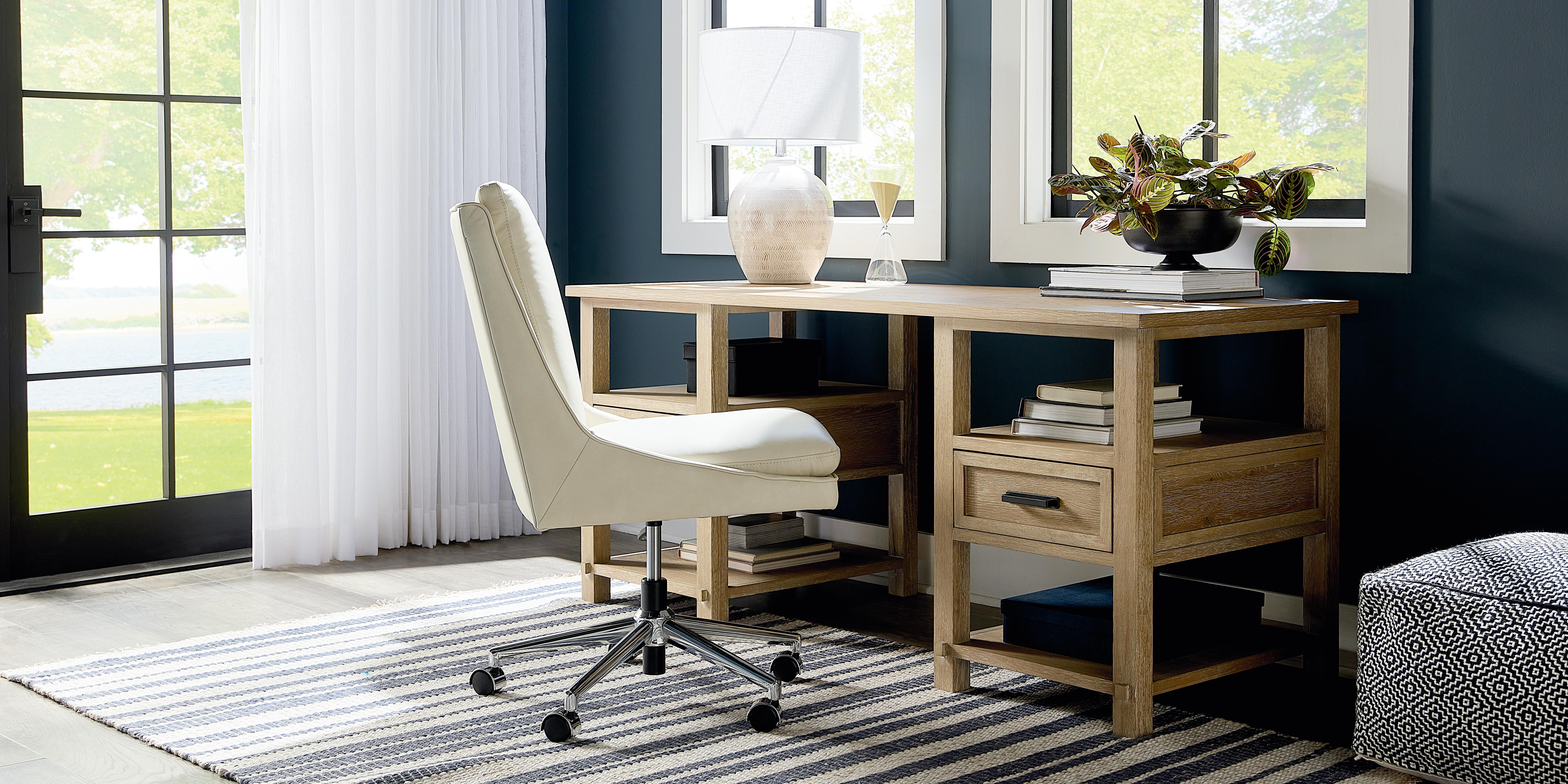 Narrow desk placed against wall with armless desk chair